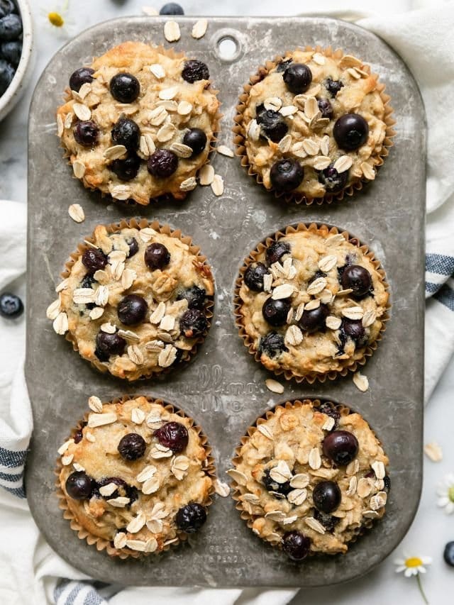 Overhead view of a muffin tin of freshly baked blueberry muffins. 