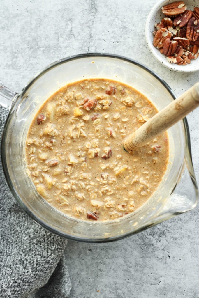 Overhead view into large mixing bowl with pour spout of gingerbread baked oatmeal ingredients.